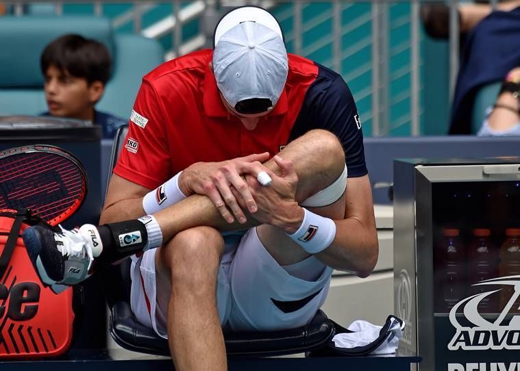 John Isner, dos Estados Unidos, reage após sofrer uma aparente lesão em uma partida contra Roger Federer, da Suíça (não na foto), durante os homens